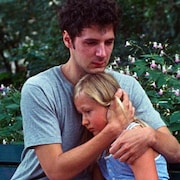 Sur un banc de parc, un jeune homme (Vincent Lacoste) tient une petite fille contre lui.