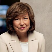 la pr&eacute;sentatrice souriante porte un veston.