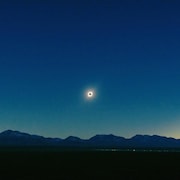 Une éclipse solaire au dessus d'une chaîne de montagnes.