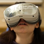 Une jeune fille porte un casque de réalité virtuelle de l'entreprise Paperplane Therapeutics lors d'un rendez-vous chez le dentiste.