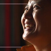 Une népalaise regarde vers le haut avec un grand sourire.