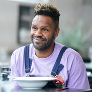 Pierre-Yves Lord est à table et il écoute quelqu'un qui lui parle.