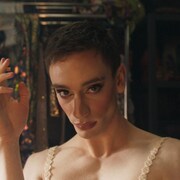 Une drag-queen (Théodore Pellerin) fixe la caméra, en fumant une cigarette.