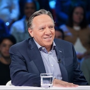 François Legault est assis dans le studio.