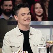 Il est assis en studio.