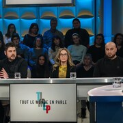 Les quatre personnes sont assises en studio.