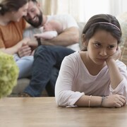 On voit une petite fille triste de l'arrivée du nouveau bébé dans la famille.