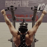 Un homme de dos qui s'entraîne à l'aide d'une machine au gym.