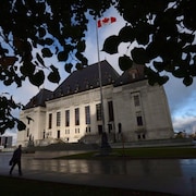 Un homme marche devant la Cour suprême du Canada.