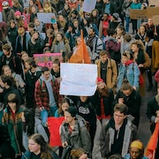 Une foule de jeunes manifestants pour le climat tenant des pancartes dans une rue de Montréal. 