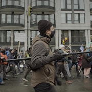 Le journaliste Simon Coutu avec sa perche et son micro dans une manifestation.