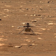 L’hélicoptère Ingenuity faisant tourner ses hélices sur la surface de Mars.
