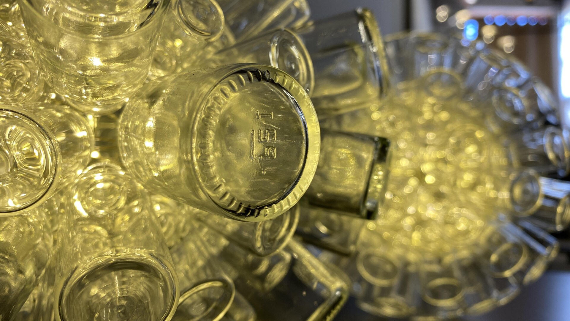 Suspension de bouteilles de verre à travers laquelle diffuse une lumière. Suspension de bouteilles de verre à travers laquelle diffuse une lumière.