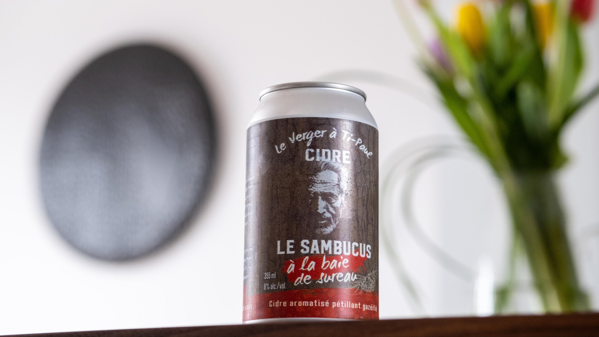 Une canette de cidre devant un bouquet de tulipes. Une canette de cidre devant un bouquet de tulipes.