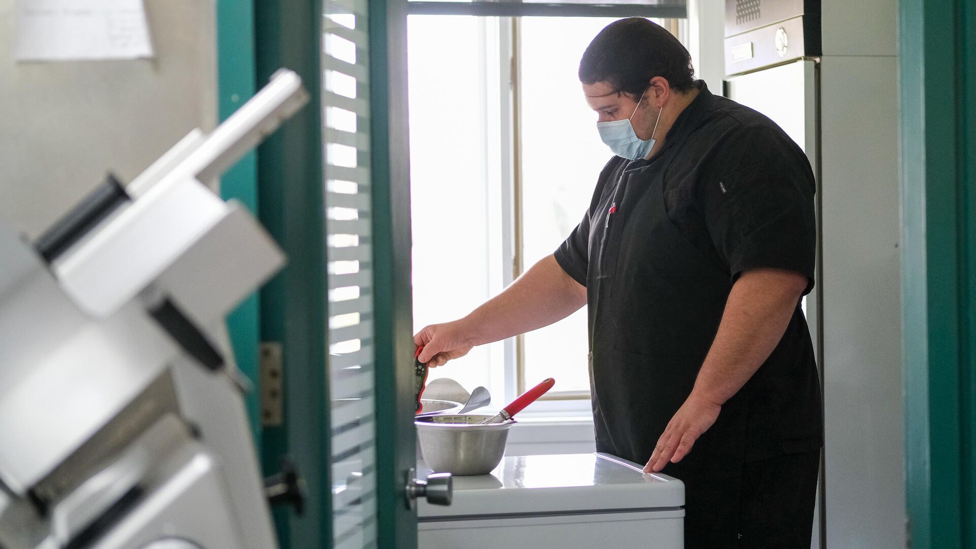 Un chef surveille la température au-dessus d'une marmite. Un chef surveille la température au-dessus d'une marmite.