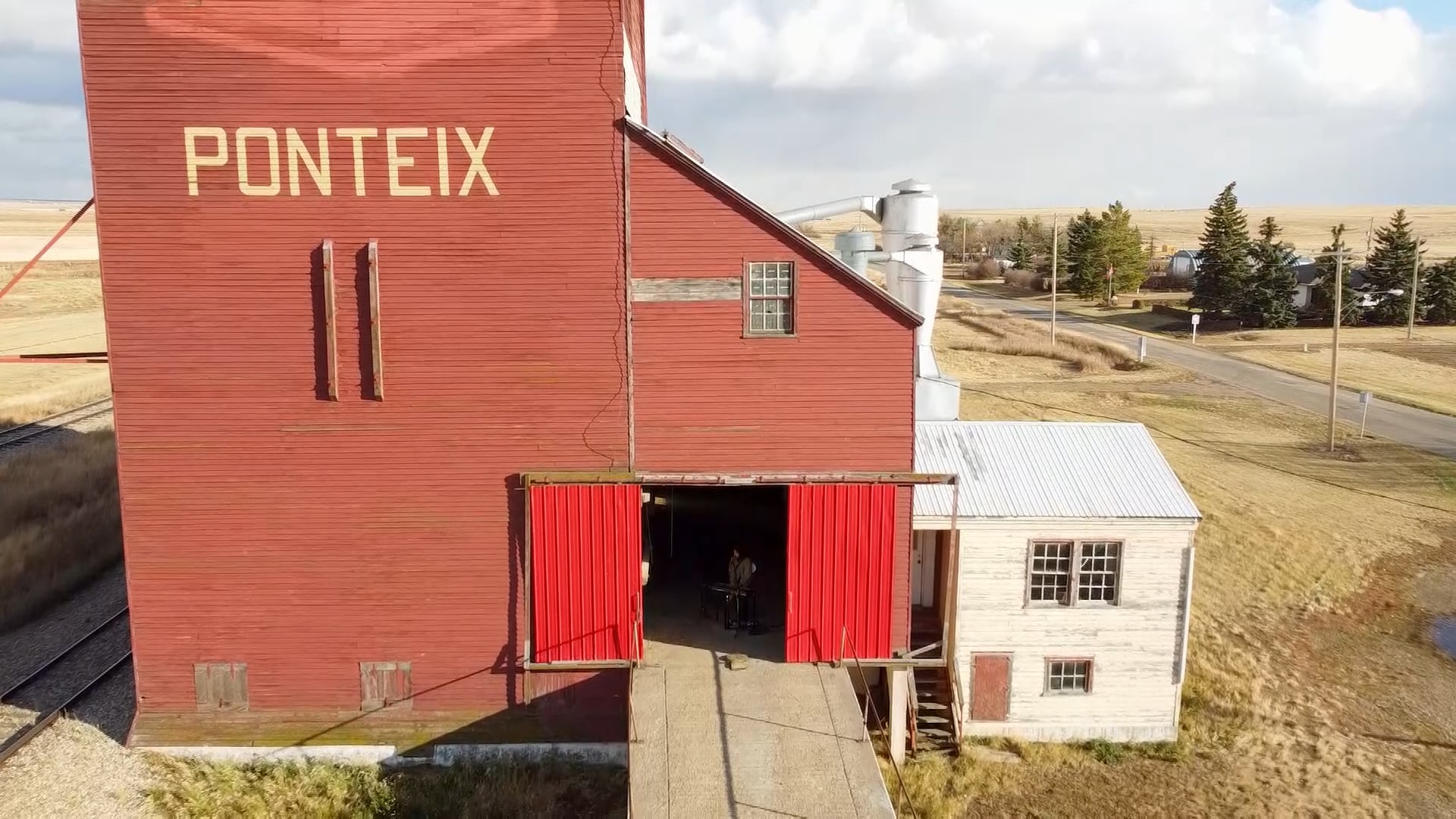 Le chanteur du groupe Ponteix chante en solo dans un silo à grains du village de Ponteix en Saskatchewan. Dans cette image de drone on l'aperçoit dans l'ombre devant son clavier.