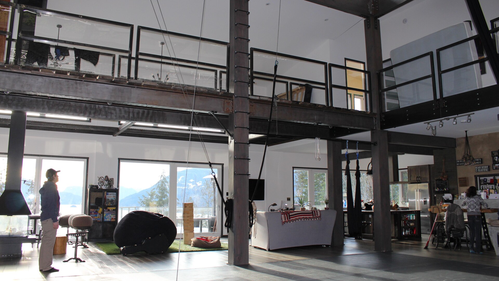 Intérieur d'une maison à espace ouvert avec plafond haut, d'allure industrielle.