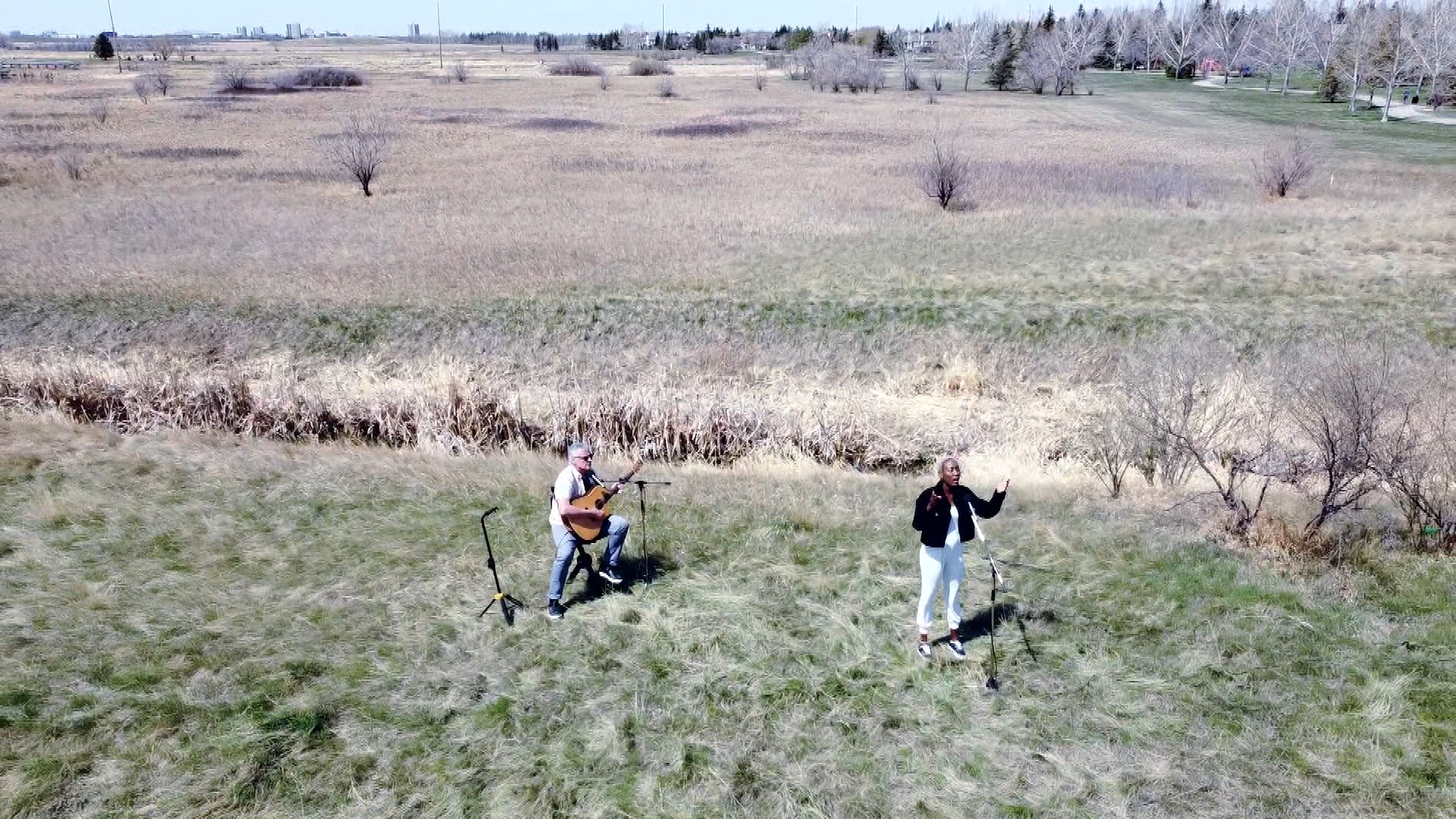 Une image aérienne de la chanteuse Nyenimana et du guitariste Dave Lawlor dans un champs tout près de Regina. 