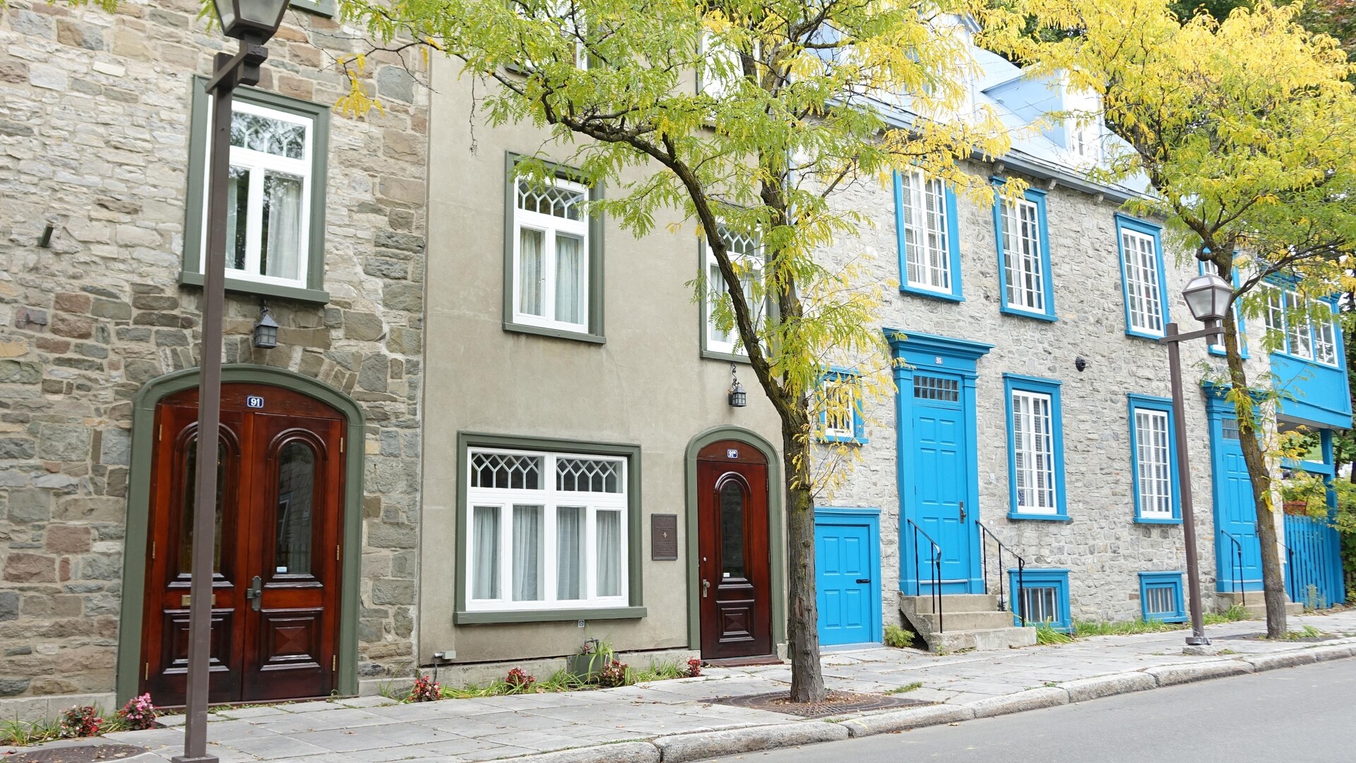 Une belle série de maisons mitoyennes aux magnifiques portes de bois vernis se côtoient à l'ombre des arbres d'un secteur tranquille près de la citadelle. 