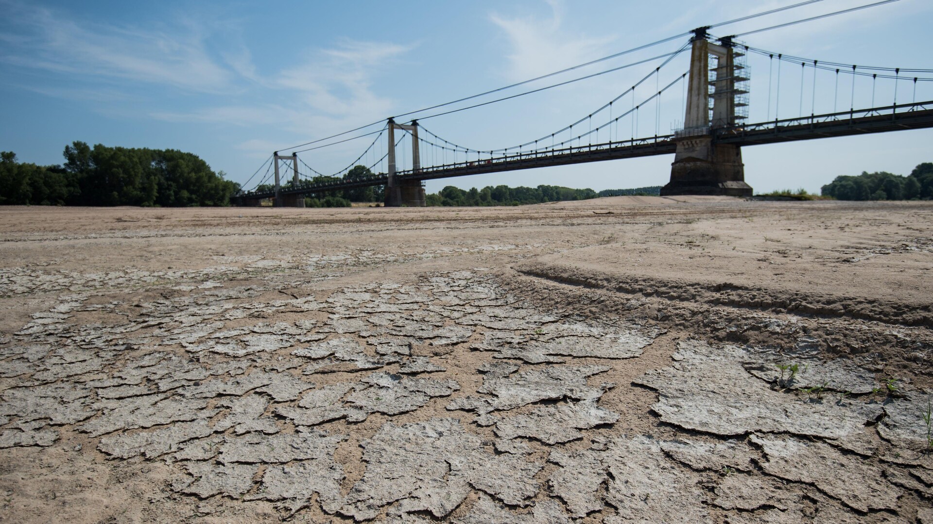 Un pont surplombe un fleuve asséché, en France.