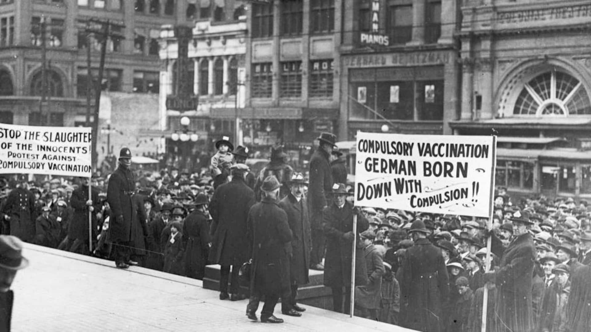 Une foule anti-vaccin brandit des pancartes et manifeste devant l'Hôtel de Ville de Toronto dans les années 1930. Une foule anti-vaccin brandit des pancartes et manifeste devant l'Hôtel de Ville de Toronto dans les années 1930.