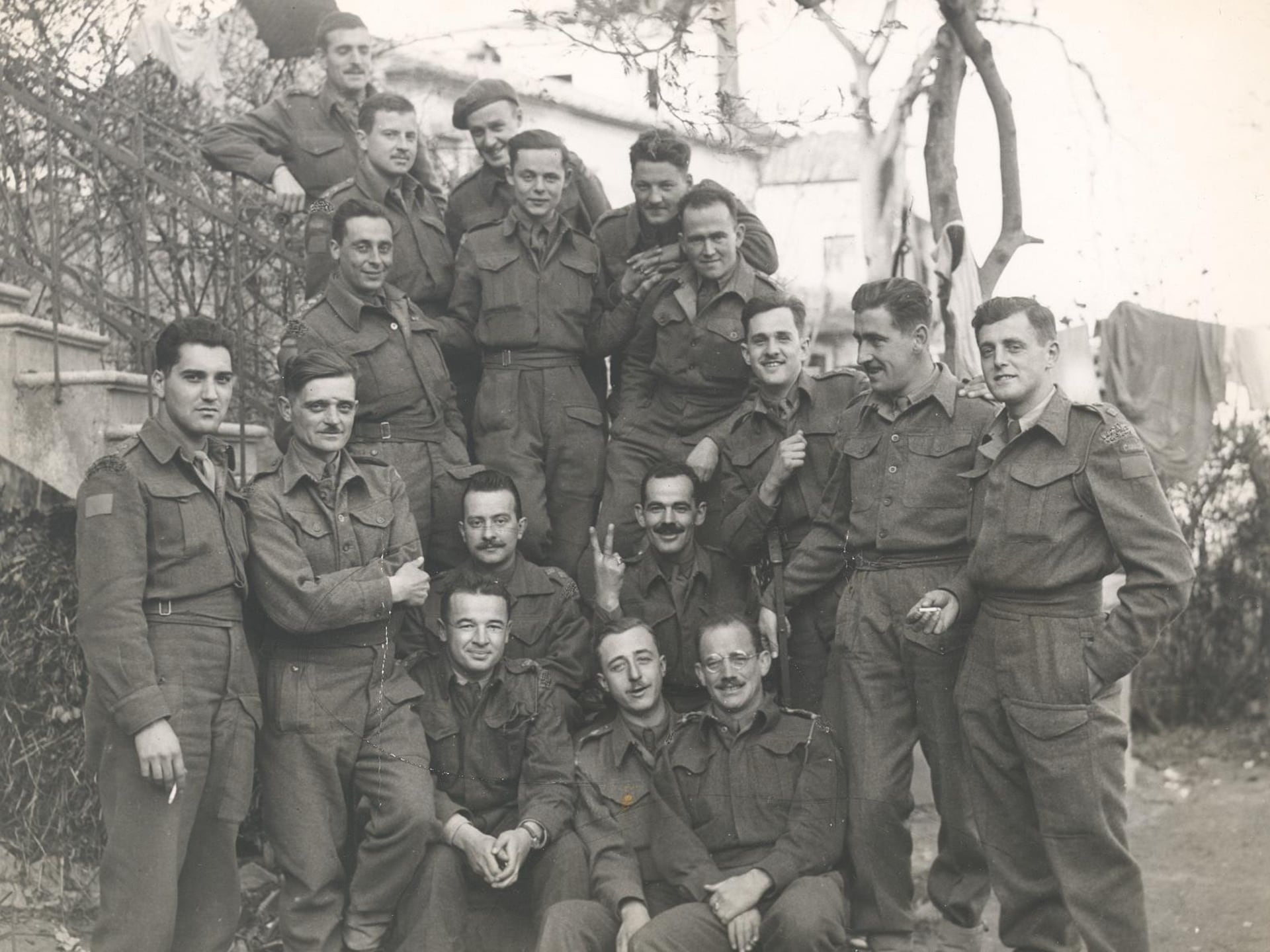 Officiers souriants du Royal 22e Régiment en Angleterre, en octobre 1942 - on sent leur complicité et leur optimisme, alors qu'un d'eux fait le V de la victoire, au centre de l'image