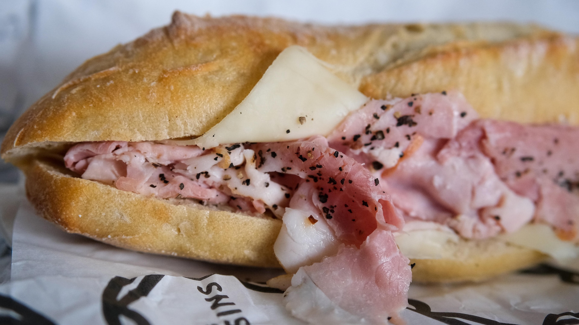 Un sandwich jambon beurre sur un papier blanc et noir. Un sandwich jambon beurre sur un papier blanc et noir.