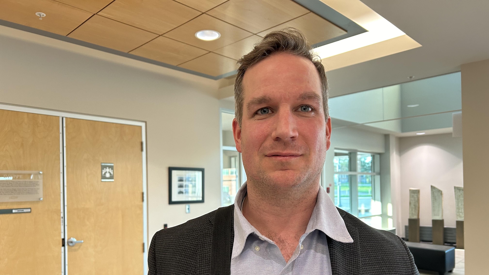 Un homme sourit à la caméra. 