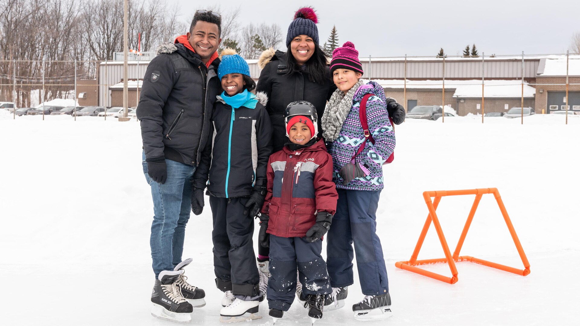 Une famille pose tout sourire sur une patinoire