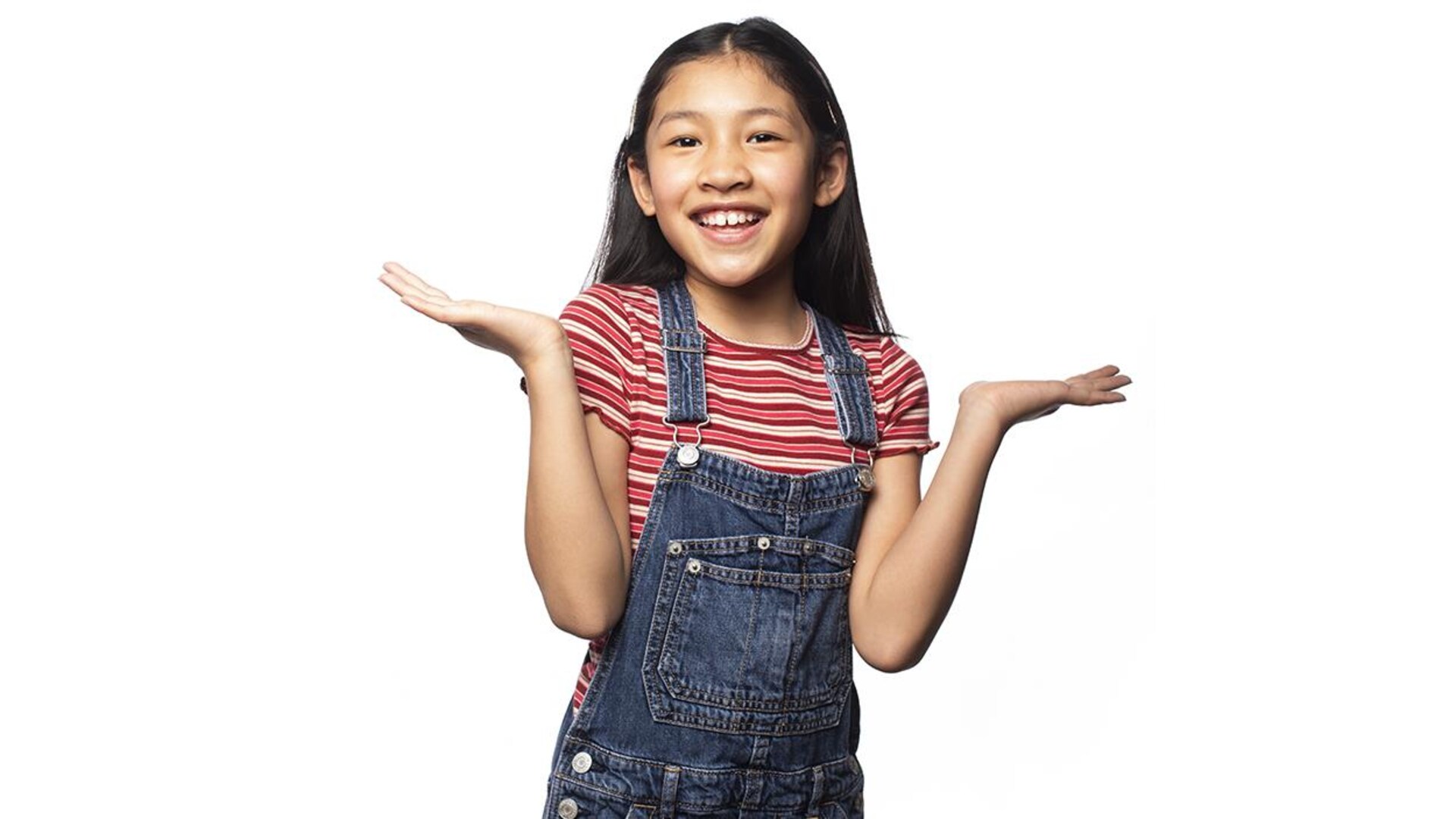 Petite fille asiatique souriante portant une salopette
