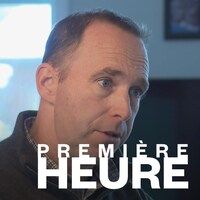 Un homme aux cheveux brun en discussion avec une autre personne.