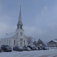 Des véhicules sont stationnées devant l'église de Saint-Gabriel-de-Rimouski en hiver.