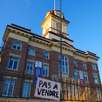Une pancarte indiquant Pas à vendre est accrochée à une barrière devant l'ancienne mairie de Saint-Boniface.