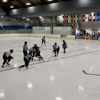 Des joueurs de hockey jouent dans un aréna.                 