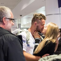 Alexis Roy-Godin embrasse sa copine à son arrivée à l'aéroport Montréal-Trudeau.