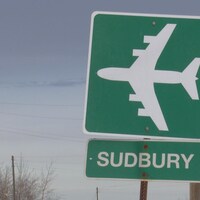 Une pancarte de bord de route indiquant la direction vers l'aéroport de Sudbury.