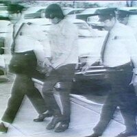 Donald Marshall, menotté, escorté par des policiers.