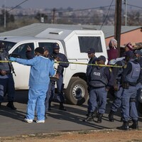 Des policiers sud-africains franchissent un cordon de sécurité.