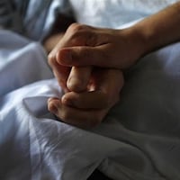 Deux mains sur un lit