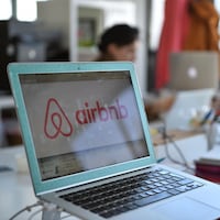 Sur un ordinateur portable, une fenêtre pour réserver un logement sur Airbnb est ouverte.