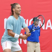 Un joueur de tennis s'apprête à retourner le service de son adversaire.