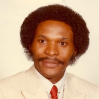Photo d'un homme noir avec une moustache et un afro.