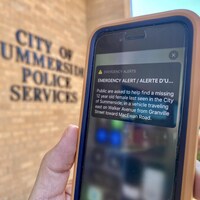 Une alerte d'urgence sur un iphone placé devant le mur de l'édifice de la police municipale de Sumerville.