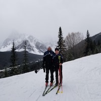 Le skieur André Bourque et sa fille sur une montagne enneigée. 