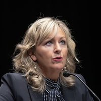 Gros plan de la ministre des Affaires municipales, Andrée Laforest, assise durant une conférence de presse.