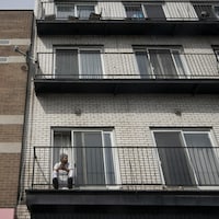 Un homme seul sur son balcon.