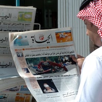 Une photo d’archives datant de juillet 2005, montrant un Saoudien qui tient une copie du quotidien Al-Hayat devant un kiosque de journaux dans la capitale Riyad.