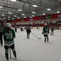 Des joueuses de hockey pratiquent sur une glace intérieure.