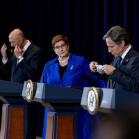 Quatre dirigeants politiques derrière des lutrins lors d'une conférence de presse