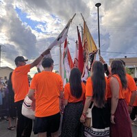 Un groupe de marcheurs innus joignent leurs drapeaux